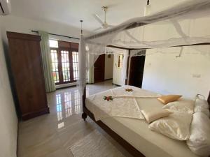 a bedroom with a large bed with a canopy at Villa Alex in Beruwala