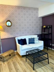 a living room with a white couch and a table at Les Pénates de Loire in Ancenis