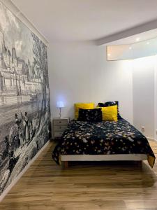 アンスニにあるLes Pénates de Loireのベッドルーム1室(ベッド1台付)が備わります。壁には絵画が飾られています。