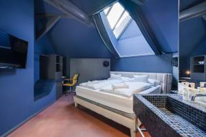 a blue bedroom with a bed and a window at Butik Apartments, by BQA in Budapest