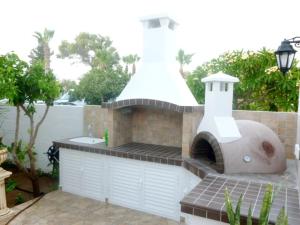 a outdoor kitchen with a pizza oven in a backyard at Philippou Beach Villas & Apartments in Larnaka