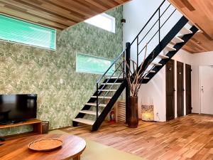 Una sala de estar con escalera y televisor. en Kawaguchiko Villa FJ Resort, en Fujikawaguchiko 29 fotos más