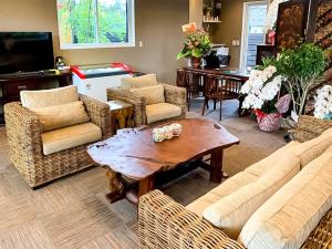 sala de estar con sillas de mimbre y mesa de madera en Kawaguchiko Villa FJ Resort, en Fujikawaguchiko