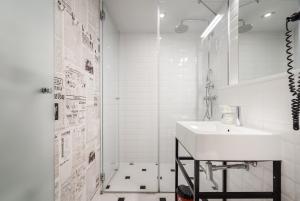 uma casa de banho branca com um lavatório e um chuveiro em Butik Apartments, by BQA em Budapeste