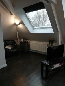 a living room with a large skylight and a couch at La maison de la Vallée in Froissy