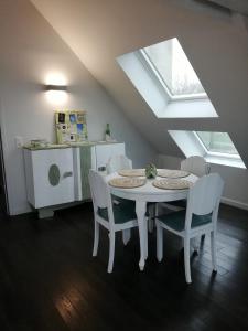 a white table and chairs in a kitchen with a window at La maison de la Vallée in Froissy