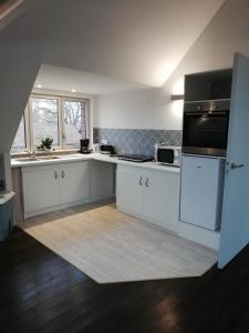 a kitchen with white cabinets and a black microwave at La maison de la Vallée in Froissy +6 photos