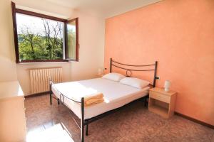 a bedroom with a bed and a window at Residence Corte del Bosco in Garda