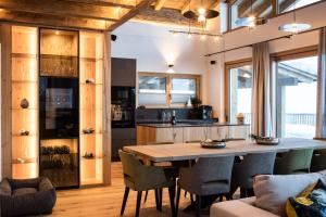 cocina y comedor con mesa de madera y sillas en Das Chalet., en Mühlbach am Hochkönig