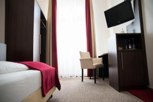 a hotel room with a bed and a television at Heerens Hotel in Emden +14 photos