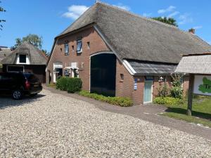 a brick house with a car parked in front of it at B&B en Appartementen Triënte in Buinen