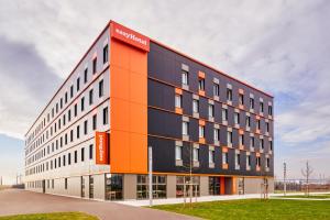 un bâtiment de bureau avec une façade orange et noire dans l'établissement easyHotel Paris Charles de Gaulle Villepinte, à Tremblay-en-France