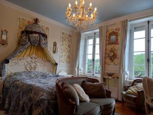 ein Schlafzimmer mit einem großen Bett und einem Kronleuchter in der Unterkunft Maison de la riviere in Port-Launay
