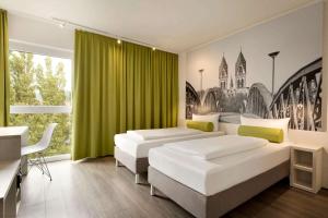a bedroom with a large bed and a painting on the wall at Super 8 Freiburg in Freiburg im Breisgau