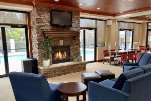 Comfort Suites Augusta Riverwatch في أوغوستا: لوبي فيه موقد وطاولة وكراسي