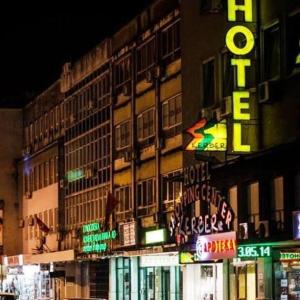 a building with neon signs on the side of it at Hotel Kerber in Podgorica