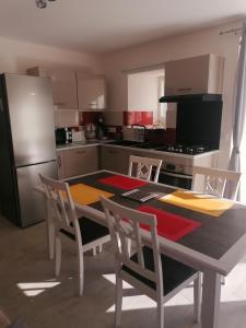 a kitchen with a table and chairs and a refrigerator at La basse-cour in Vic-sur-Cère