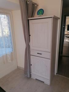 a white cabinet in a room next to a door at La basse-cour in Vic-sur-Cère