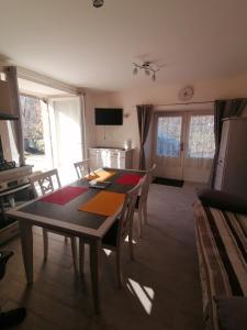 un comedor con mesa y sillas en una habitación en La basse-cour, en Vic-sur-Cère