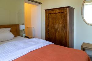 um quarto com uma cama e um armário de madeira em DK Glasmanufaktur GmbH em Wurzbach