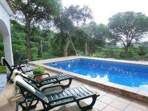 a swimming pool with two lawn chairs next to it at 2Sena - Lloret de Mar in Lloret de Mar