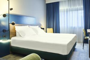 - un grand lit blanc dans une chambre d'hôtel dans l'établissement Belstay Milano Assago, à Assago