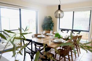 a dining room with a wooden table and chairs at Harbour Haven*Sea View*WIFI*Wine*Walk to the Beach in Robe