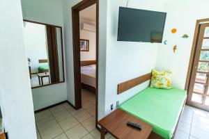 ボンビーニャスにあるPousada Canaãの緑のベンチと鏡が備わる部屋