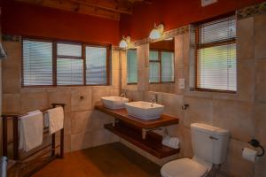 a bathroom with two sinks and a toilet at Bush Villas on Kruger in Phalaborwa