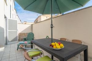 a table with a bowl of fruit and an umbrella at Casa Pilar in Alcudia