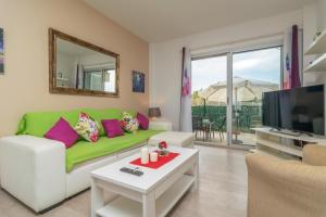 a living room with a green couch and a tv at Casa Pilar in Alcudia