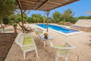 une terrasse avec des chaises, une table et une piscine dans l'établissement Canaus, à Porreres