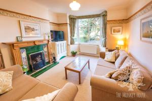 een woonkamer met een bank en een open haard bij The Monkey House B&B in Stone