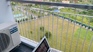 a laptop on a balcony with a view of a field at Son's Condo SMDC Wind Tagaytay in Tagaytay