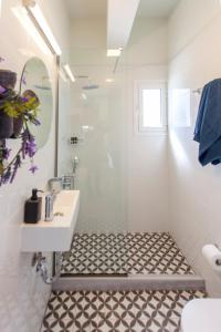 a white bathroom with a sink and a shower at Ligia Waterfront Apartments in Lygia