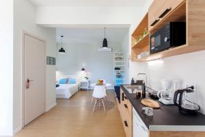 a kitchen and living room with a bed in the background at Ligia Waterfront Apartments in Lygia