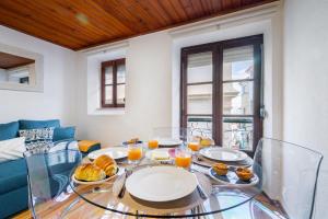 a glass table with plates of food on it at WHome Beco Patacas Perfect location to explore Lisbon in Lisbon