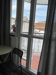 d'une fenêtre avec une chaise donnant sur un balcon. dans l'établissement Slavija Square Apartments, à Belgrade