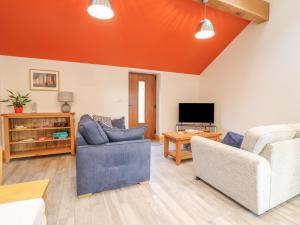 uma sala de estar com dois sofás e uma televisão em Pipistrelle em Stoke-on-Trent