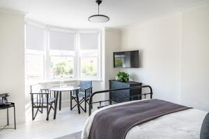 um quarto com uma cama, uma mesa e cadeiras em Doghouse Margate em Kent