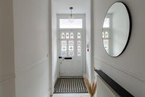 a hallway with a mirror and a white door at Doghouse Margate in Kent