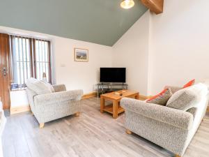 a living room with two chairs and a flat screen tv at Robin's Rest in Stoke on Trent