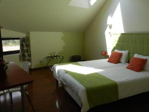 a bedroom with two beds and a table and a window at L'HÔTEL de CHARTRES in Chartres