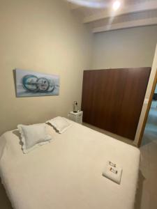 een slaapkamer met een groot wit bed met een houten hoofdeinde bij Costa Luxe Planta Alta in Posadas