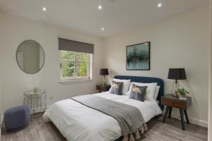 a bedroom with a large bed and a mirror at 3 bedroom Windsor Garden apartment by Gleneagles in Blackford