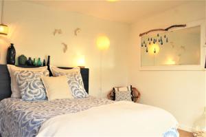 Schlafzimmer mit einem Bett mit blauen und weißen Kissen in der Unterkunft L'Abri du Marin in Audierne