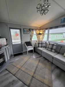 a living room with a couch and a fireplace at Cairnryan Heights 2 Bed caravan holiday home in Stranraer