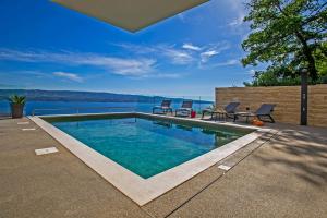 a swimming pool with a view of the water at Villa Dispet, sea view, pool, jacuzzi, sauna, cinema in Omiš