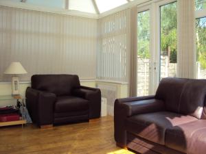 a living room with a couch and a chair at Birchwood Private Room for Homestay in Risley