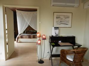 a bedroom with a bed and a desk with a piano at L'HÔTEL de CHARTRES in Chartres